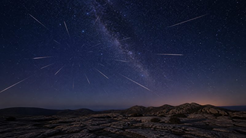 Aynı gökyüzü noktasından yayılıyormuş gibi görünen meteor izlerini gösteren özgün kapak